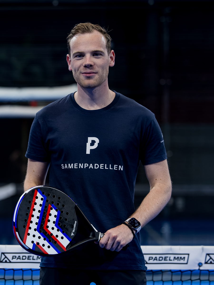 Speler met racket op de blauwe padelbaan